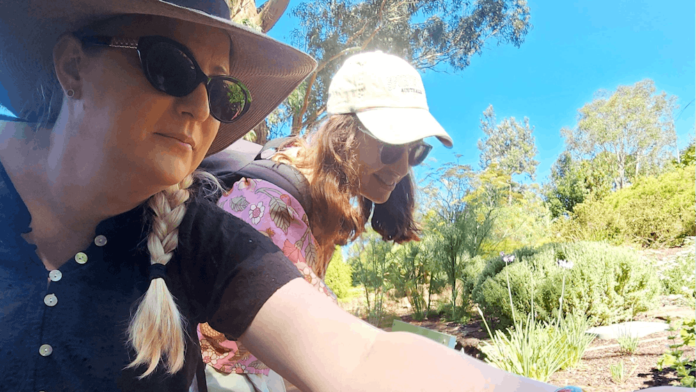 two women touching plants