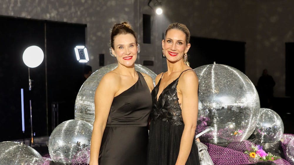 Two glamorous ladies posing in front of disco balls
