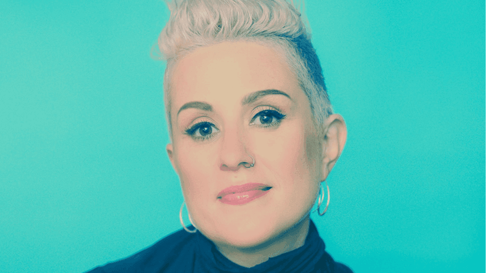 Katie standing in front of an aquamarine blue background