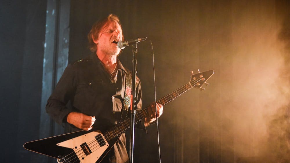 Andy Kent on bass guitar singing on stage
