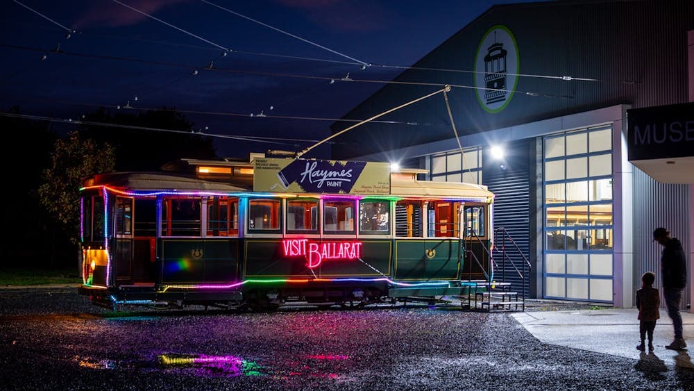 An illuminated heritage tram outside the Museum