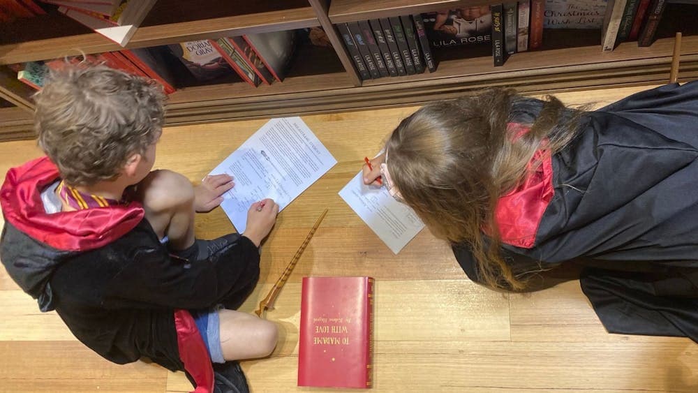 Children sitting on the floor filling in a treasure hunt