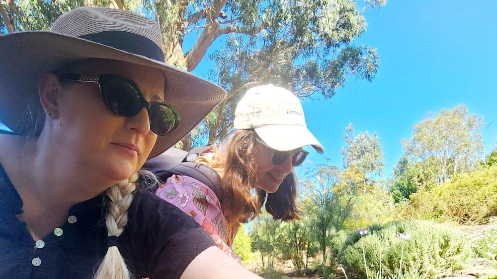 two women touching plants