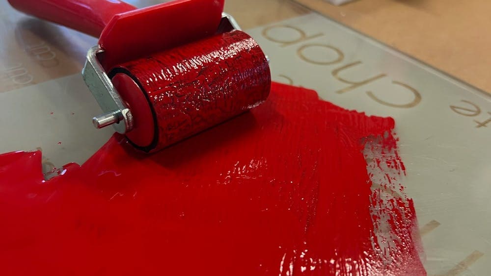 A  roller and red ink on glass