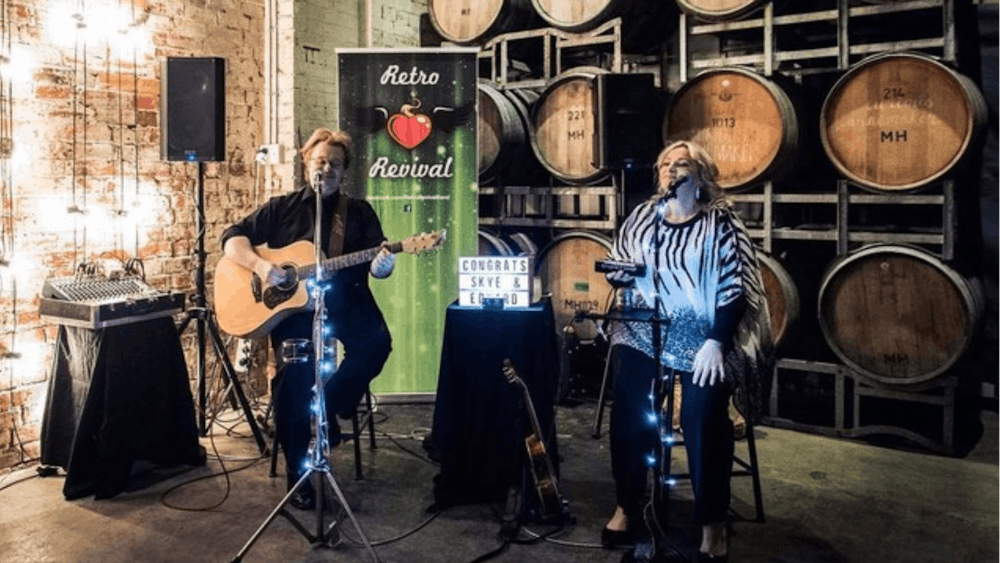 Man playing guitar and singing while woman sings at Live Saturday Night at Hop Temple edit