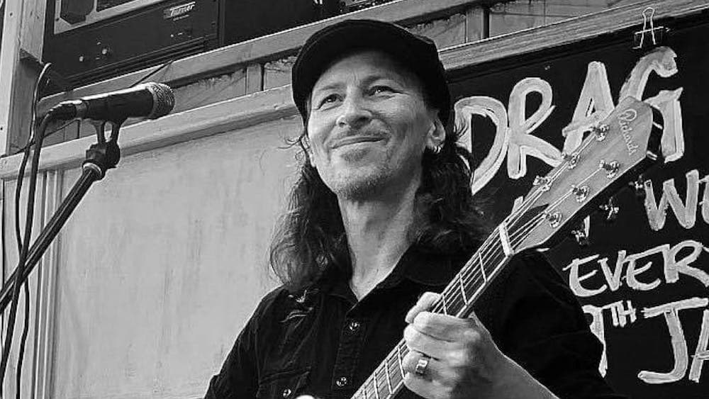 Artist holding a guitar at Blues, Brews and Barbeque at Hop Temple
