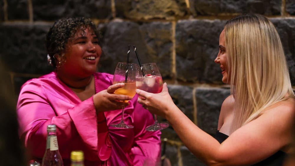 two women clinking glasses at Itinerant Spirits cocktail making class