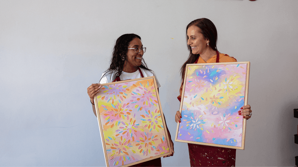 women  holding their paintings
