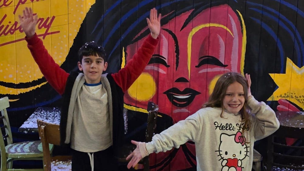 Two children at Hop Temple posing against a colourful wall