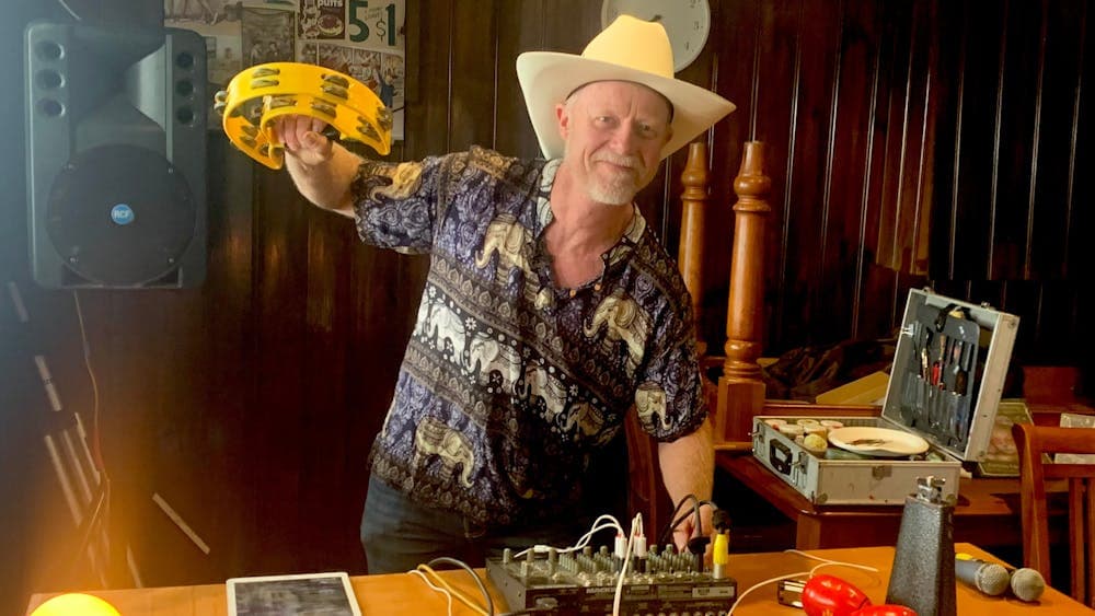 man wearing a cowboy hat and holding a tambourine