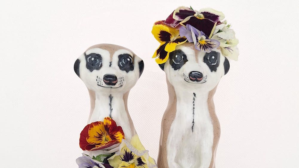 two ceramic meerkats