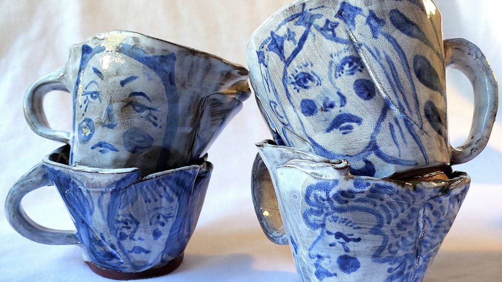 two piles of blue and white mugs