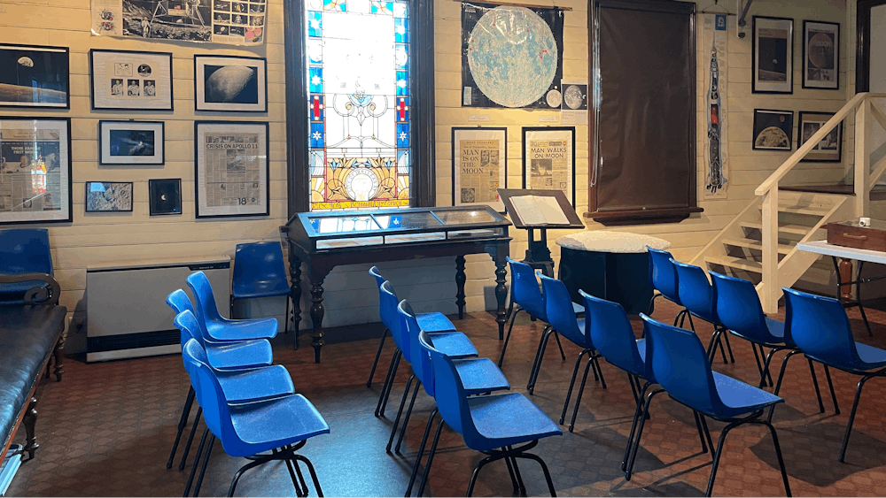 room with chairs, poster, and coloured glass window