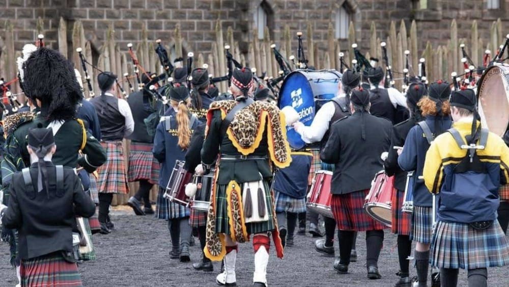 people in kilts with band equipment