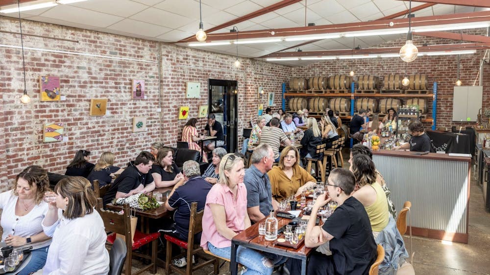 a crowded room of people at various tables enjoying each other's company