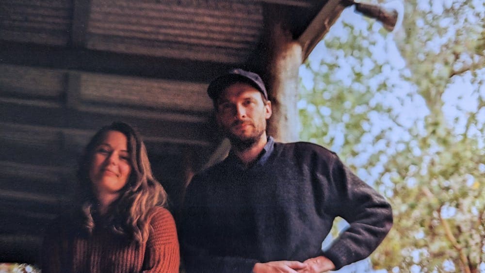 A mand and a woman standing side by side under a tin room