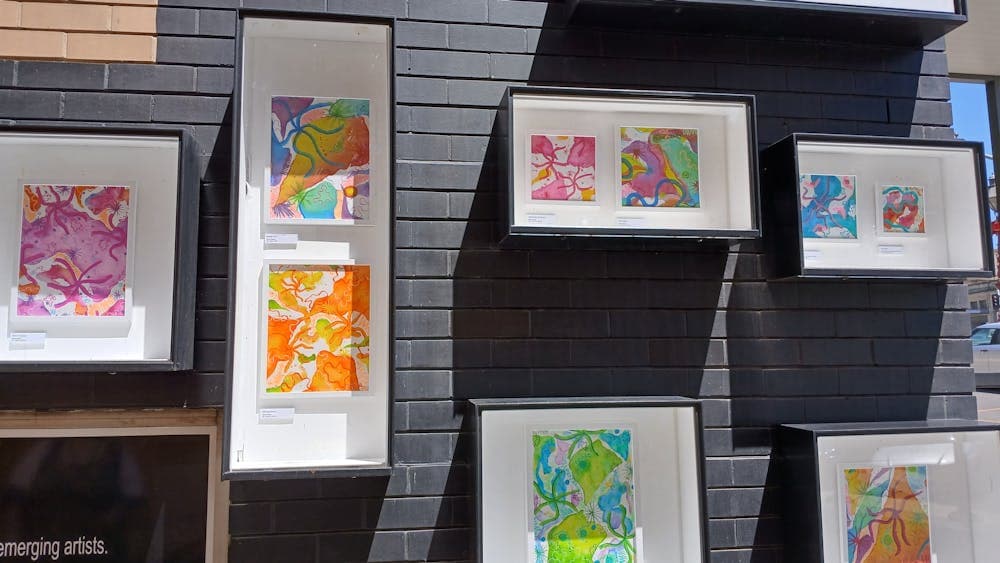 Installation of brightly painted sea creatures in an outdoor gallery display.