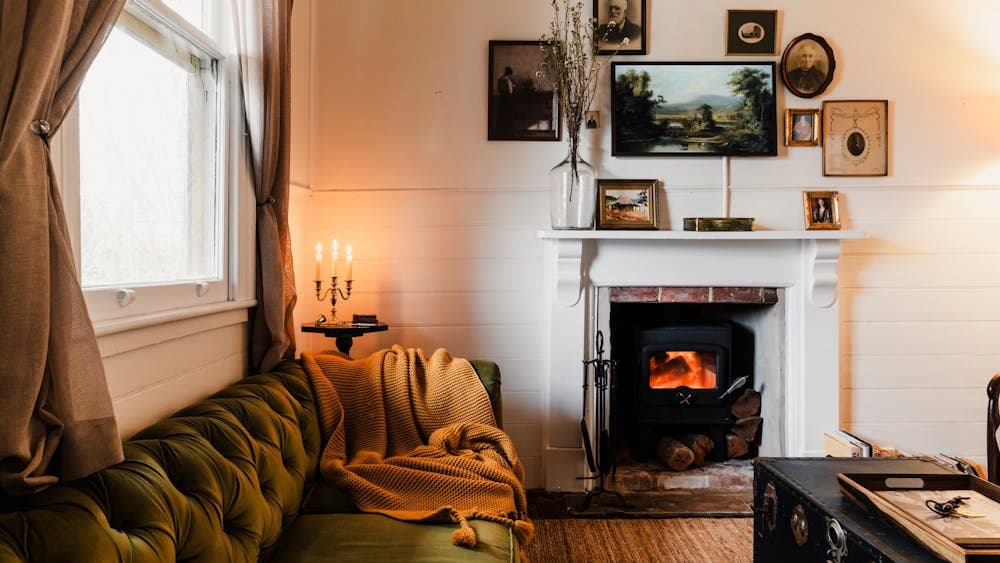 Green lounge and wood burner in sitting room