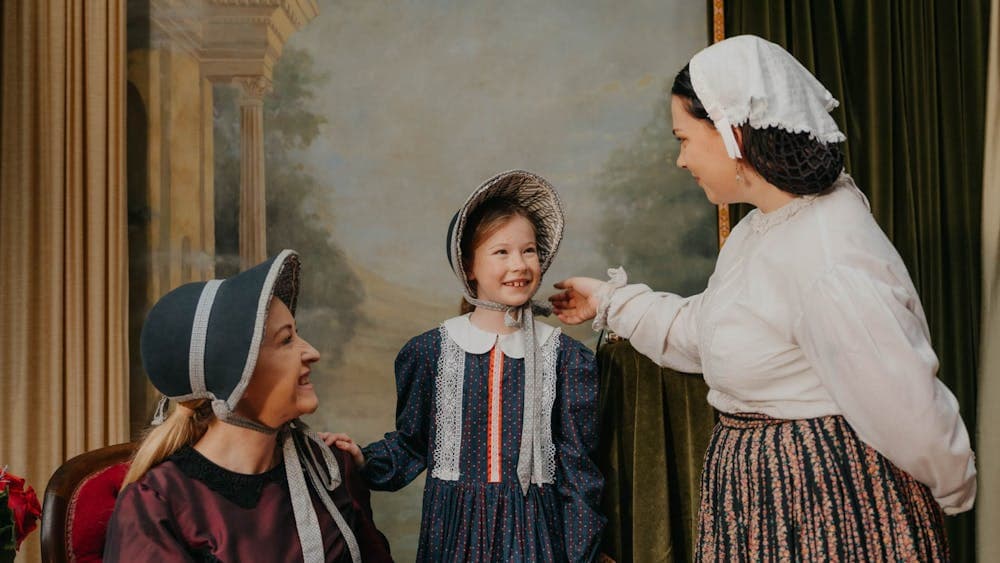 Mother and daughter in costume inside Sovereign Hill photography studio with costumed woman