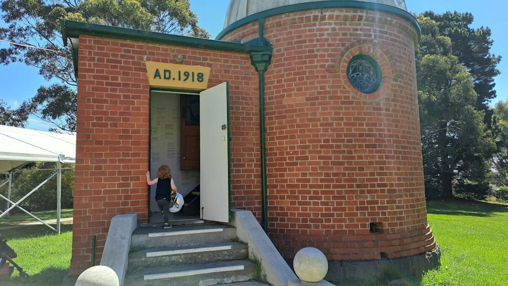 child walking up steps of observatory dome building