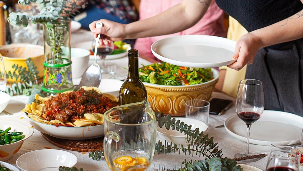 Dishes placed on the table with crockery and glasses of wine