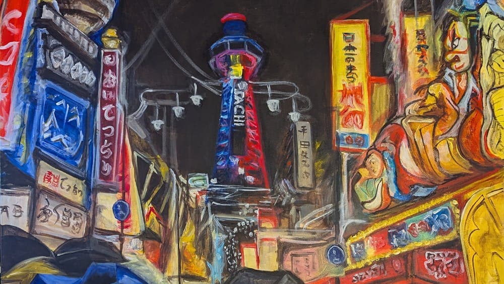 Night scene with Tokyo tower in centre, umbrellas open in the front and brightly lit buildings.