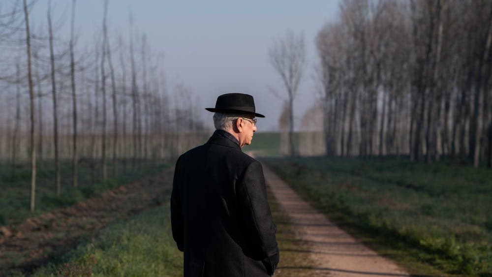 Man stands in empty road in coutryside