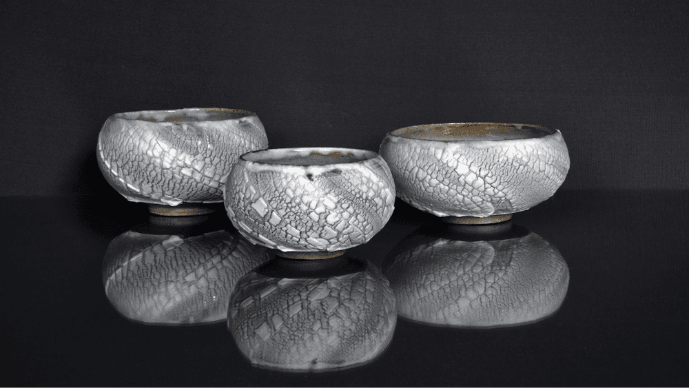 White slip over black pots on black background
