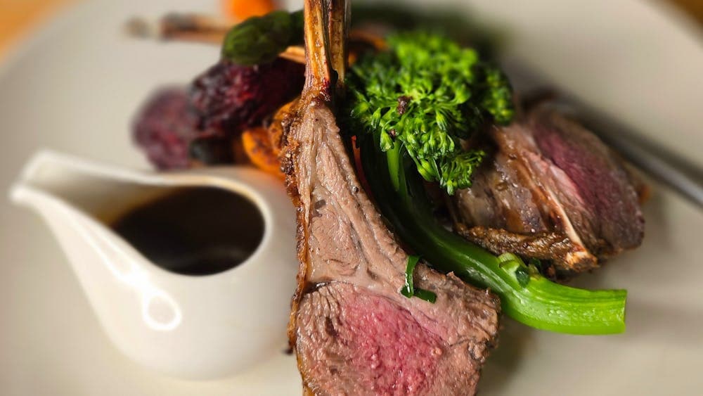 Garlic and Rosemary crusted rack of Lamb served with roasted root vegetables and red wine jus.