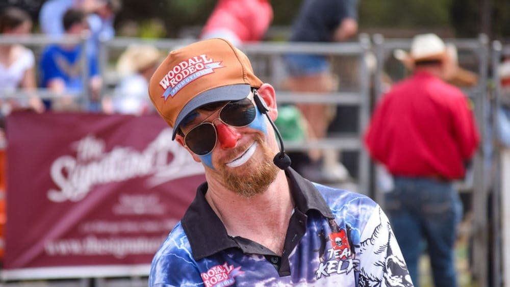 A rodeo clown smiles sarcastically at the camera