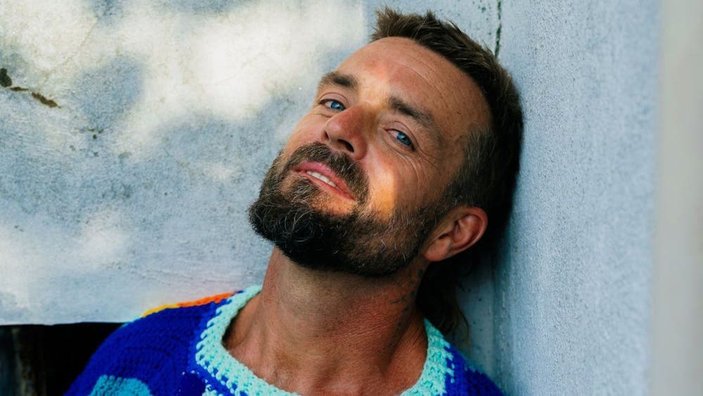 Xavier Rudd in a colourful crochet top
