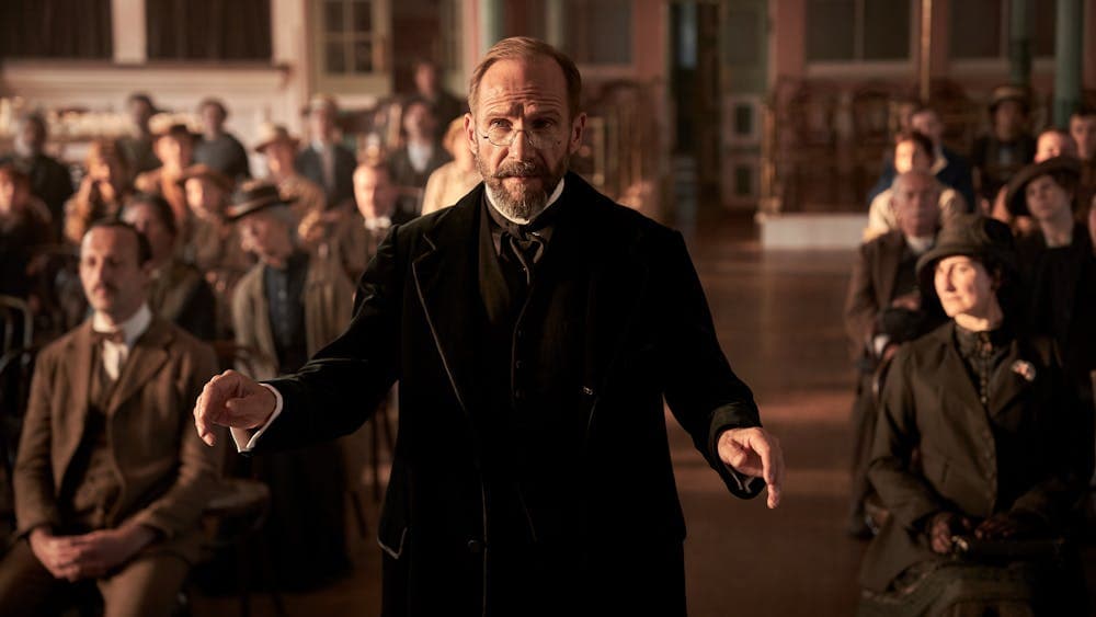 Man conducting stands in front of audience