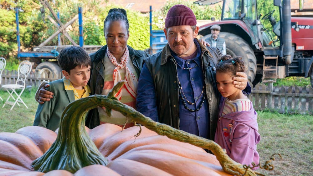 Family stands behind giant pumpkin