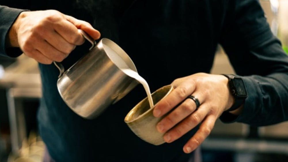 Barista pouring coffee in a cup