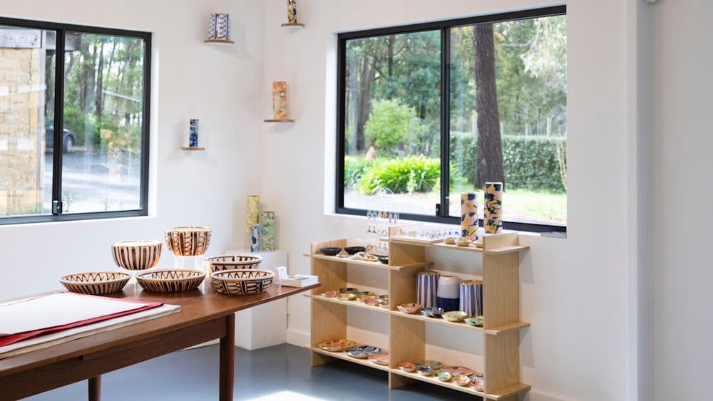 Inside a white gallery space with shelving and pots