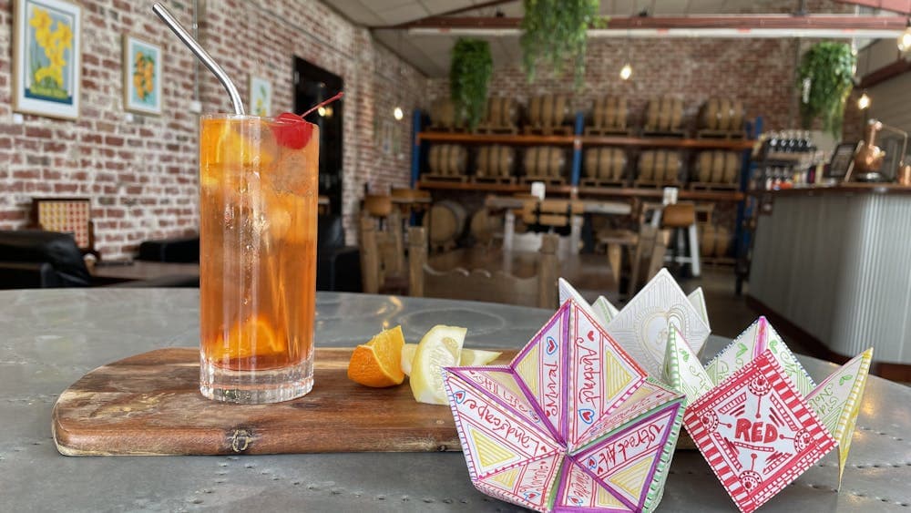 Image shows glass filled with cocktail and fruit selection alongside a paper chatterbox