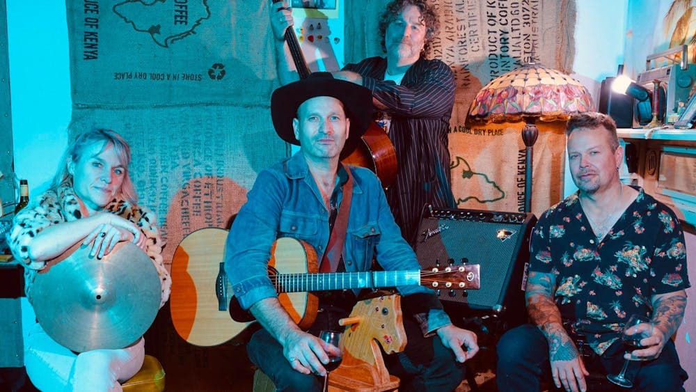 Four band members sitting with instruments