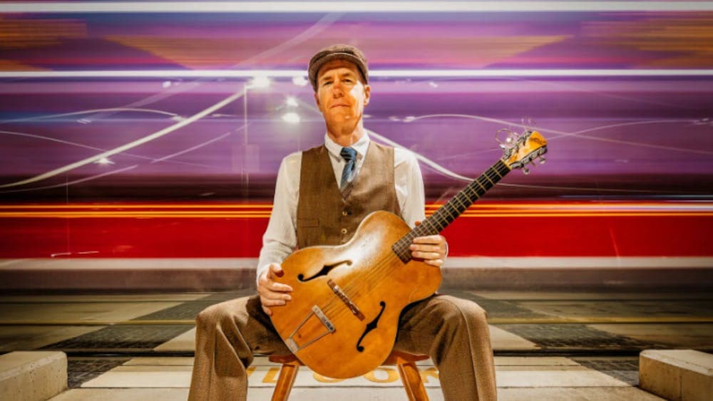 A man sitting in a chair holding a guitar