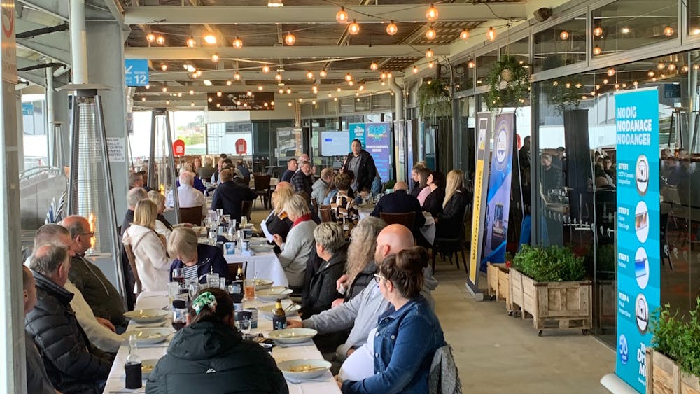 People sitting at tables outdoors, undercover