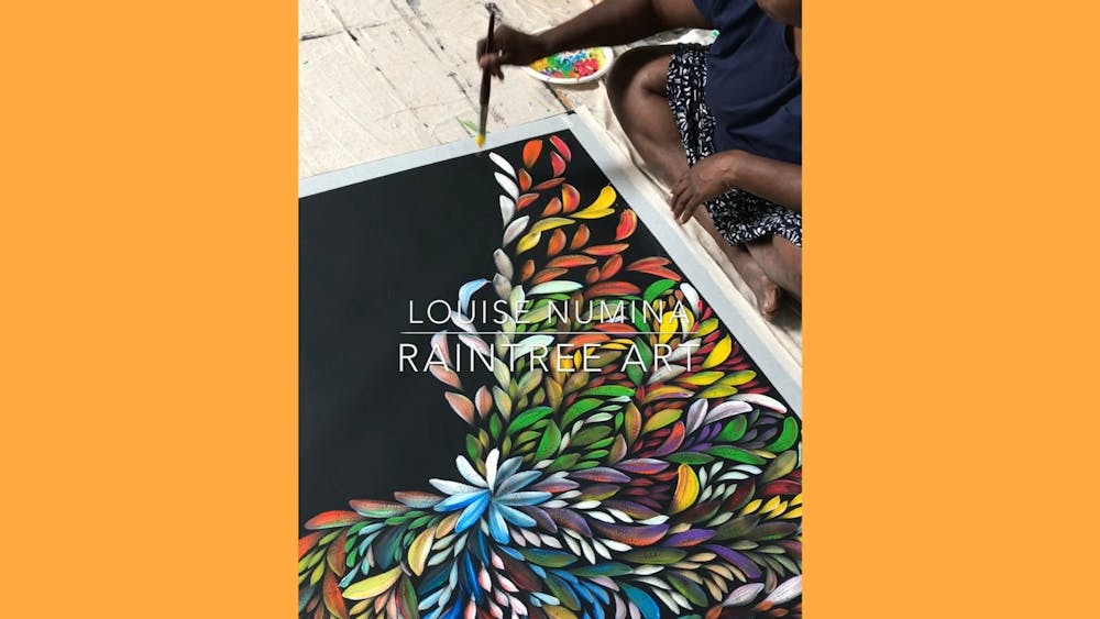 Aboriginal artist Louise Numina sits by canvas and paints bush medicine leaves