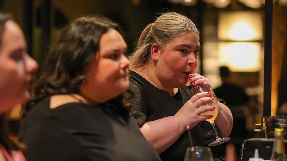woman sipping on a cocktail at Itinerant Spirits cocktail making class