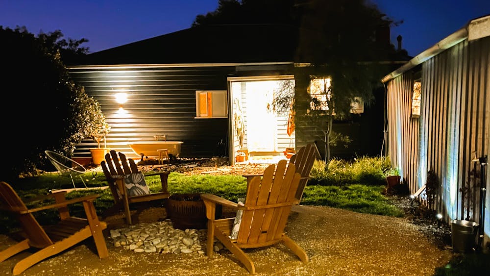 backyard fire pit, chairs, grass, outdoor bath at dusk