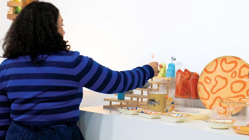 A shopper in a stripy jumper browsing ceramics