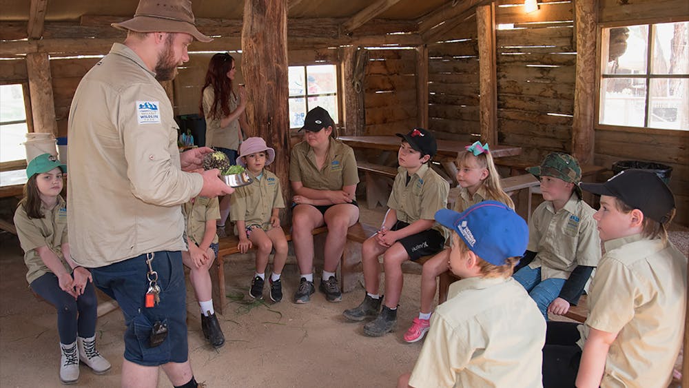 Zoo keeper and children preparing animal food