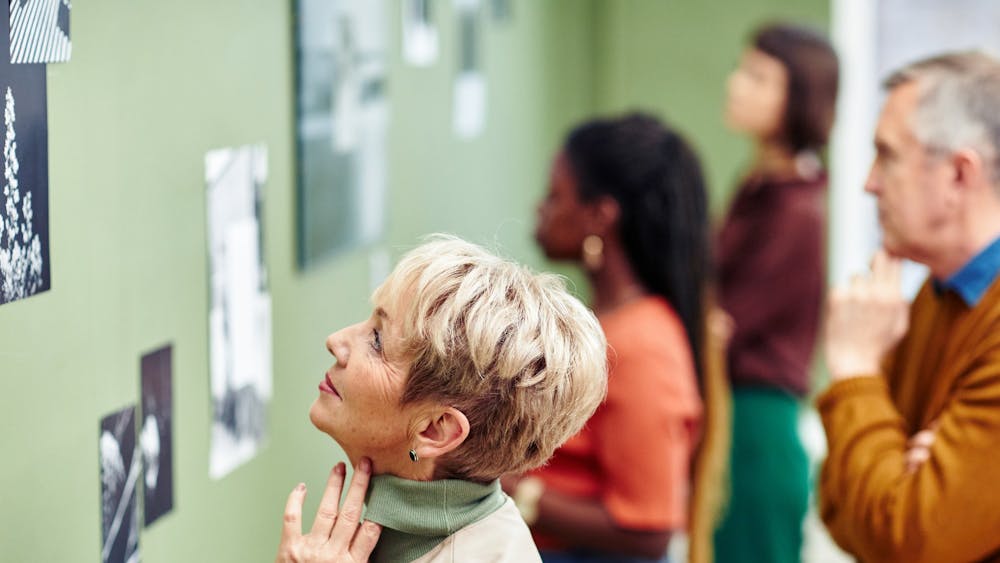 An image of an artists paintbrush resting on a dark blue picture with white splatter stars