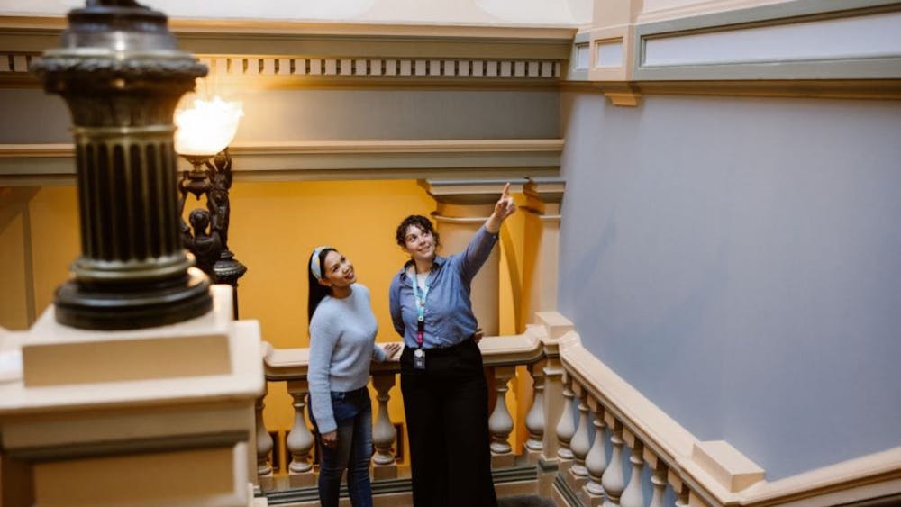 A visitor servicing staff member directing a tour participant