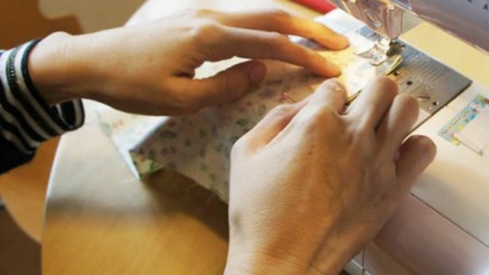 Hands sewing at sewing machine