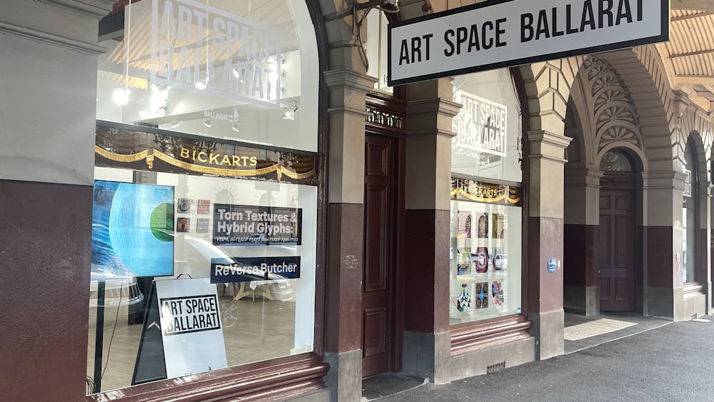 View of Art Space gallery from the street looking onto two windows and signage.