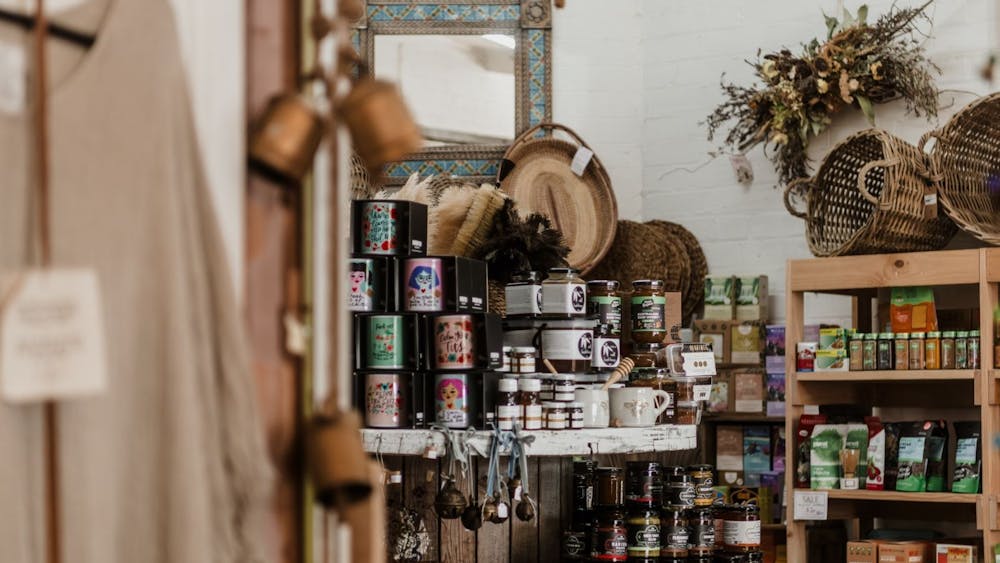 A high contrast image of a peek past a dress and hanging bells focusing on a table of pantry items