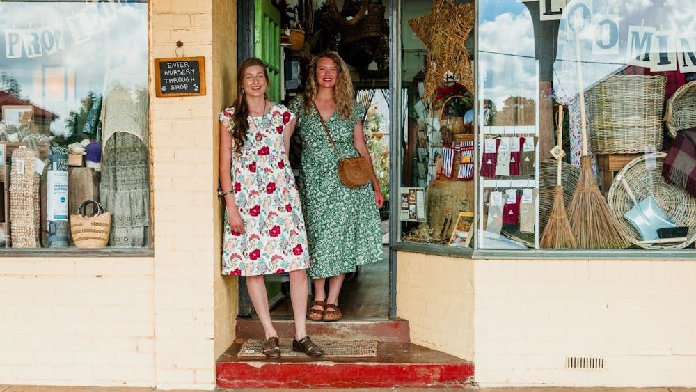 Two woman standing out the front of a store.